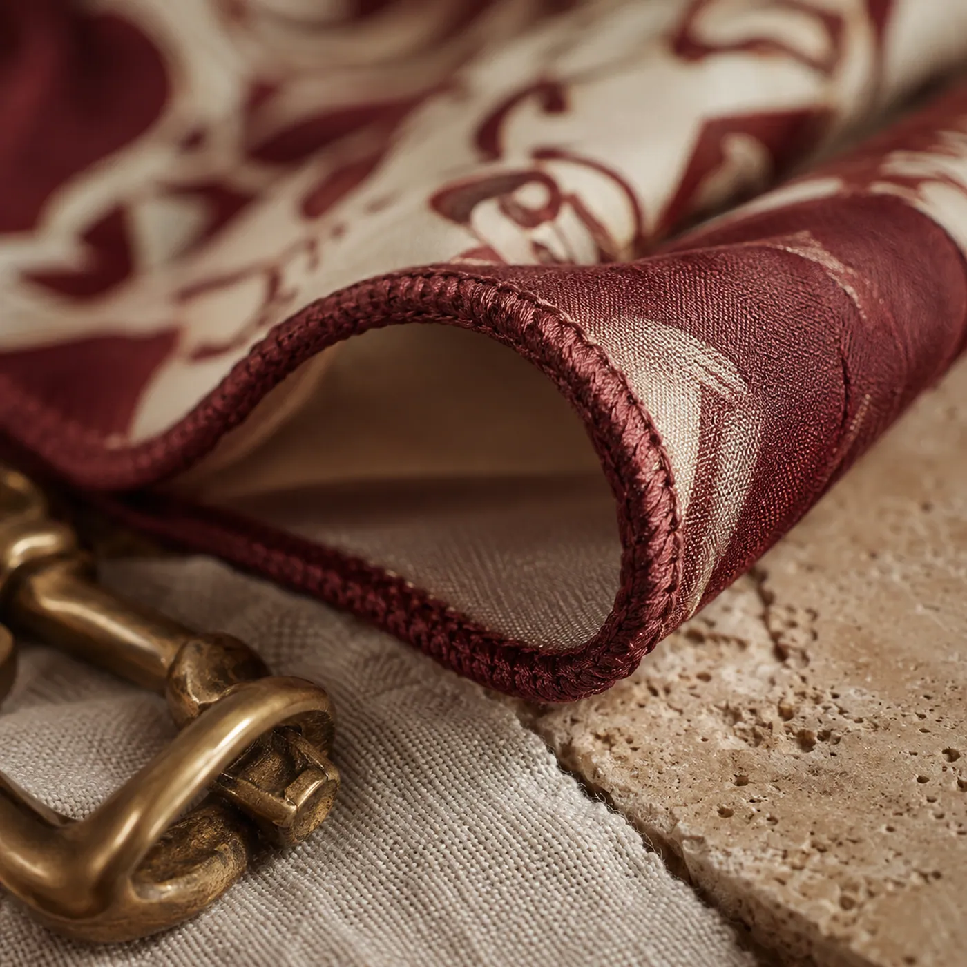 The rolled and stitched hem of a printed headscarf